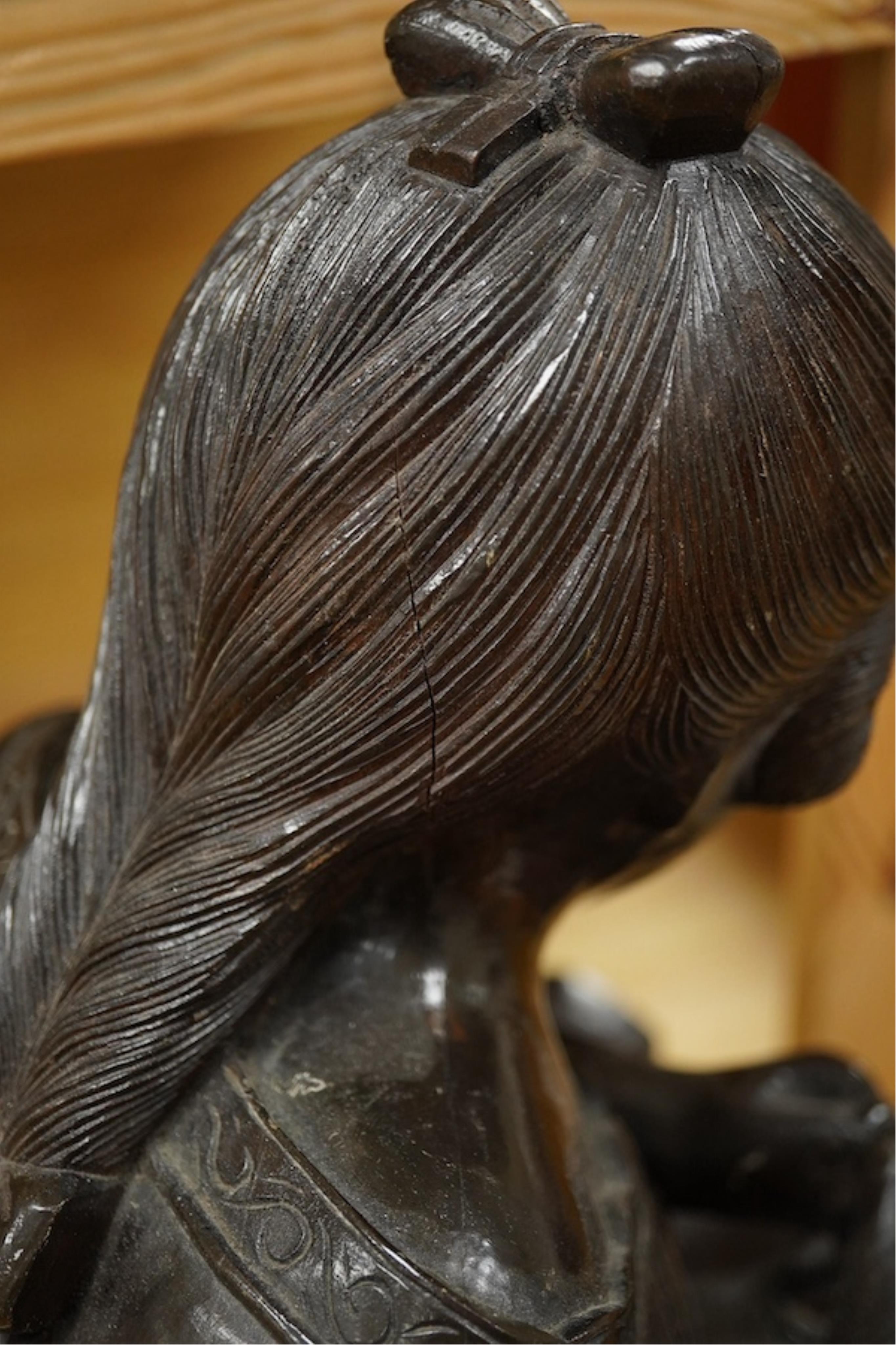 A carved wood bust of a girl sewing, 47cm high. Condition - two old cracks to the back of carving